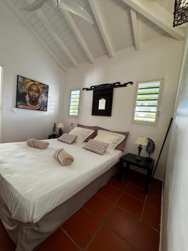a bedroom with a large bed with white sheets at Villa Douceur & Spa Piscine & Jacuzzi privés - proche plage in Saint-François