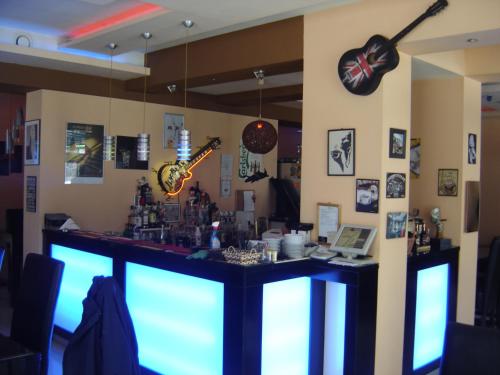 a bar in a room with a counter and a clock at Central Park Family Hotel in Kavarna