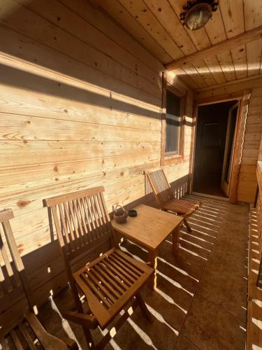 three wooden chairs and a wooden table in a cabin at Apartmaji Katrnjek in Bohinj
