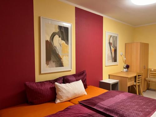 a bedroom with red and yellow walls and a bed at PensionLien in Köthen