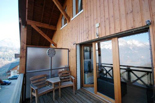 a balcony with two chairs and a glass door at Les Ecureuils Squirrel Lodge in Oz