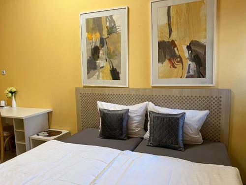 a bedroom with a bed with two pictures on the wall at PensionLien in Köthen