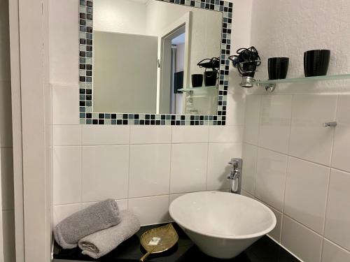 a white bathroom with a sink and a mirror at Altstadt-Hotel Gosequell in Goslar