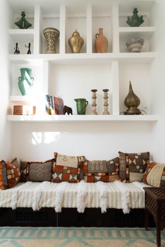 a living room with a couch with pillows on it at RIAD OASIS D'ASILAH in Asilah