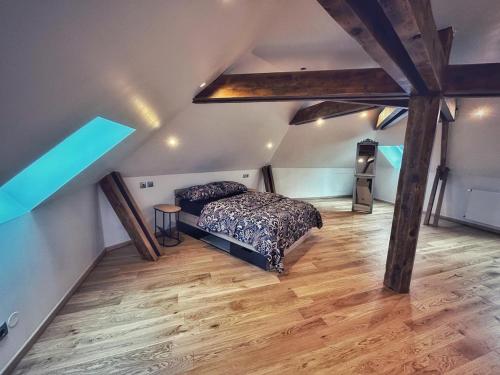 - une chambre mansardée avec un lit et du parquet dans l'établissement Grande maison moderne 5 chambres, à Cherbourg en Cotentin