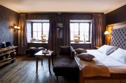 a bedroom with a large bed and a couch at Hotel Król Kazimierz in Kazimierz Dolny