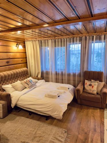 a bedroom with a large bed and a chair at BUKOWA Jezioro Żywieckie Beskid Żywiecki Śląski Sauna Jacuzzi Kominek Morsowanie Tresna Żywiec Szczyrk in Tresna