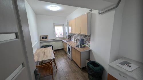 a small kitchen with a sink and a table at Alba Iulia - Apartament In Inima Transilvaniei in Alba Iulia