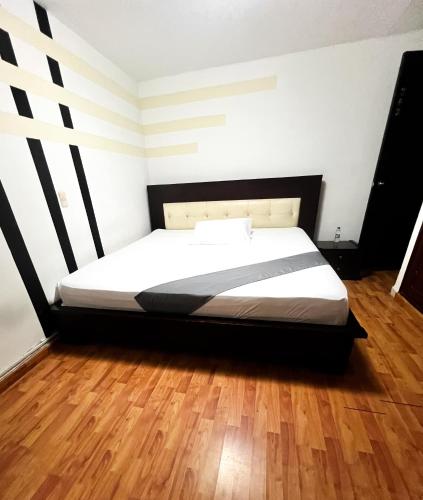 a large bed in a room with a wooden floor at Hotel Yellow Maraya, Pereira in Pereira
