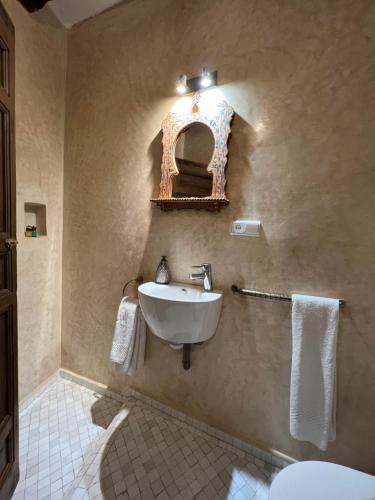 a bathroom with a sink and a mirror on the wall at RIAD OASIS D'ASILAH in Asilah