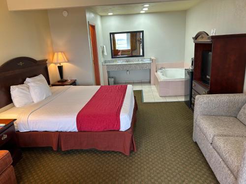a hotel room with a bed and a bath tub at Howards Inn Motel in Eunice