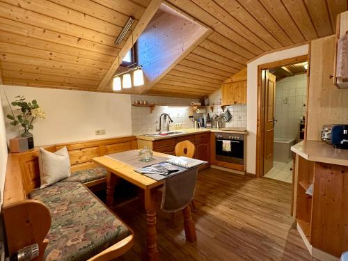 ベルヒテスガーデンにあるBergbauernhof Leitenlehenのキッチン(テーブル、ソファ付)