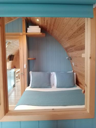 a bed in a room with a wooden ceiling at North Star Glamping in Lybster