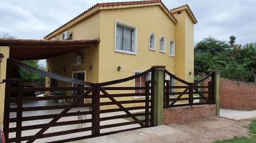 a wooden fence in front of a house at EL CHALET in Termas de Río Hondo
