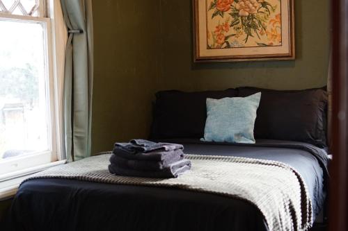 a bed with two towels on it with a window at The Rosemary in Los Angeles