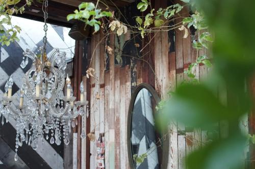 a chandelier hanging from a wooden wall with a mirror at The Rosemary in Los Angeles