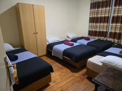 three beds in a room with wooden floors at LisBangla Guest House in Lisbon