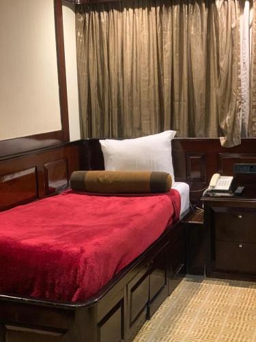 a bedroom with a bed with a red blanket and a mirror at الباخرة ريفر بوت river boat in Cairo