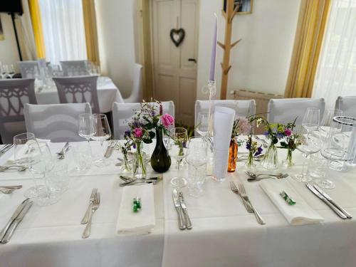 a table with white table cloths and flowers on it at Thalberghof by Taschler in Knittelfeld