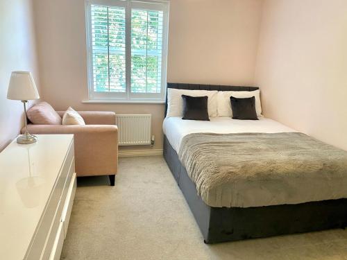 a bedroom with a bed and a couch and a window at 5 Bedroom Detached House in Milton Keynes in Bletchley