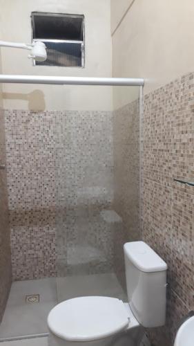 a bathroom with a toilet and a glass shower at Porto apartamento in Porto Seguro