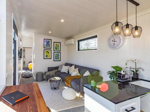 a living room with a couch and a table at Mangateitei Views - Rangataua Tiny Home in Ohakune