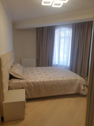 a bedroom with a bed and a window at Ботаника , парк долина роз аеропорт in Chişinău