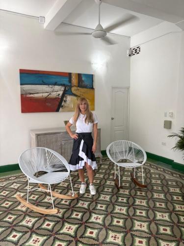 a woman sitting on two chairs in a room at Casa Turbay in Cartagena de Indias