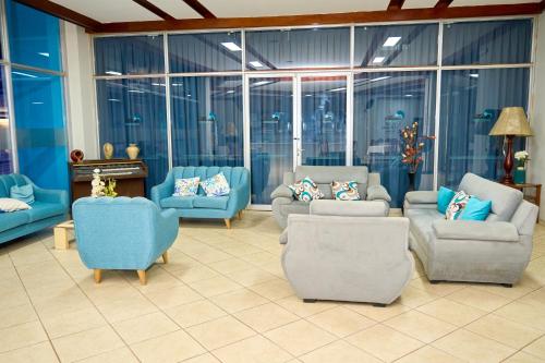 a large living room with blue furniture and large windows at Hotel Pacífico Talara in Talara