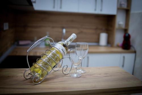 una botella y dos copas de vino en una mesa en Apartman Gold King, en Brčko