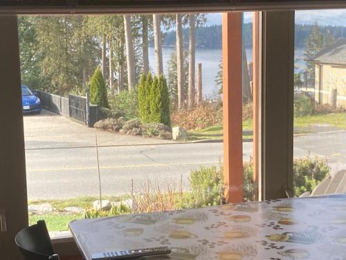 a table in front of a window with a view of a street at Beaches Downtown Suite In Sechelt in Sechelt