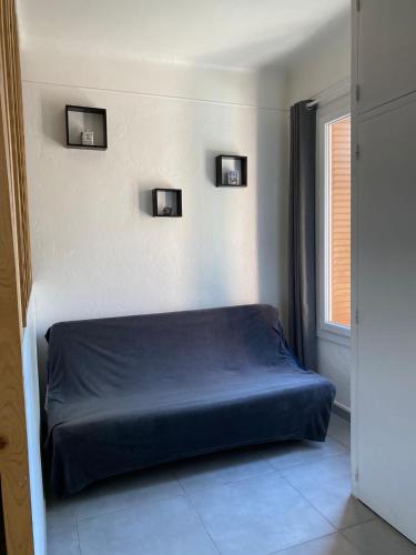 - un lit dans une chambre avec 2 photos sur le mur dans l'établissement Appartement ILIOS Cannes, au Cannet