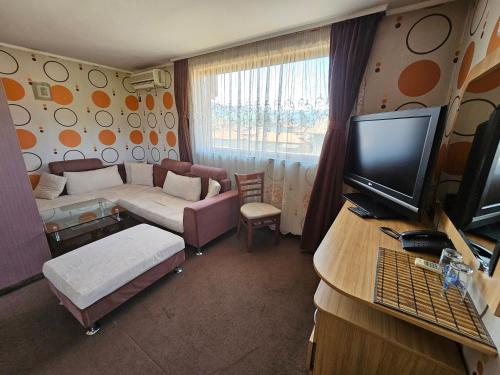 een kleine woonkamer met een bank en een tv bij Family Hotel Jeri in Velingrad