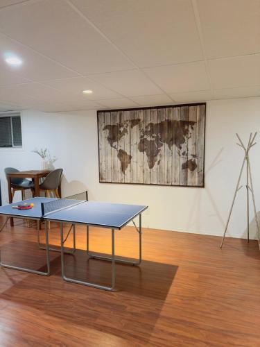 a ping pong table in a room with a map on the wall at Covepark house in Calgary