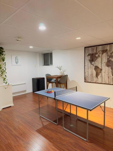 a ping pong table in the middle of a room at Covepark house in Calgary