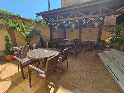an outdoor patio with tables and chairs and plants at Family Hotel Jeri in Velingrad
