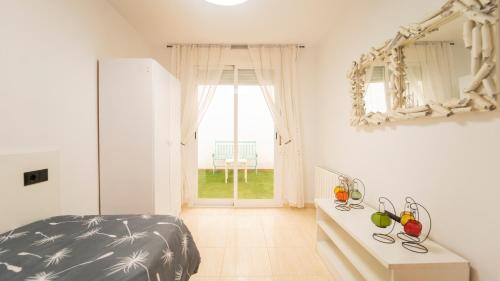 Un dormitorio con una cama y una mesa y una ventana. en H&H Suite Granada Apartament, en Armilla