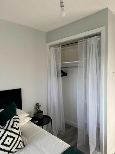ボアハムウッドにあるApartment Close to the Studiosのベッドルーム1室(ベッド1台付)、窓(白いカーテン付)
