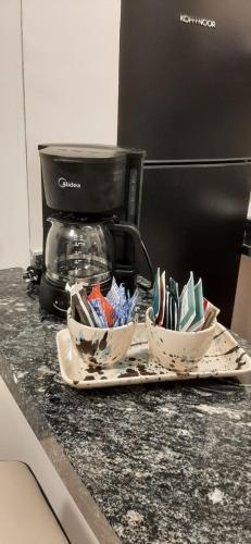 a counter with three bowls on a tray next to a coffee maker at CITY Eden Vip! en Complejo Terranova in La Falda