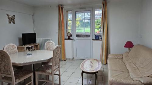 un salon avec une table et un canapé dans l'établissement Gite chez Corinne et Marc, à Rots