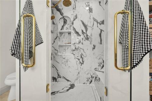 a bathroom with a shower with gold handles at The White House in Caledonia