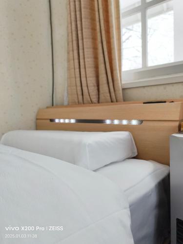 two beds in a room with a window at TERUKA白いテラスHakuba in Hakuba