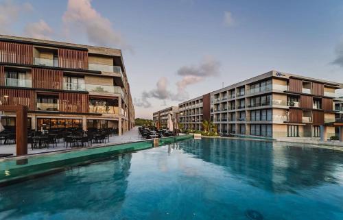 een groot zwembad voor twee gebouwen bij Flat Beira Mar Gavresorts in Porto De Galinhas