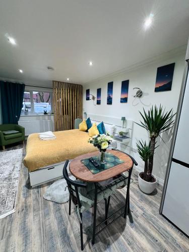 a bedroom with a bed and a table with flowers on it at Studio Flat in Wythenshawe