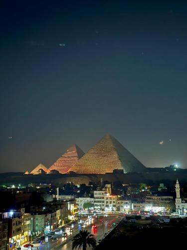 a view of the pyramids of giza at night at Piccolo Mondo Boutique Hotel in Cairo