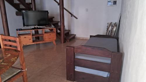 a living room with a tv and a chair at CABAÑAS KUME in Potrero de los Funes