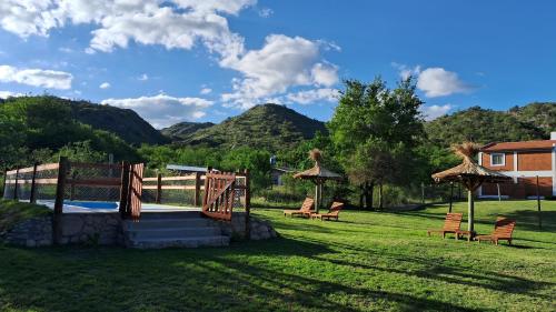 a group of chairs and umbrellas in a yard at CABAÑAS KUME in Potrero de los Funes