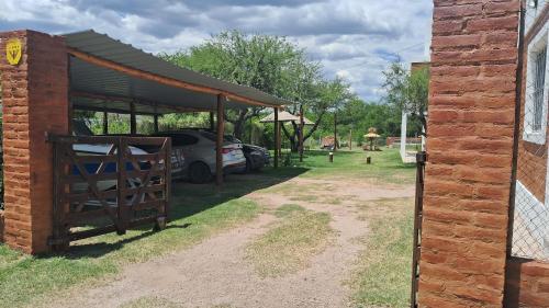 a car park with a car parked under a shed at CABAÑAS KUME in Potrero de los Funes