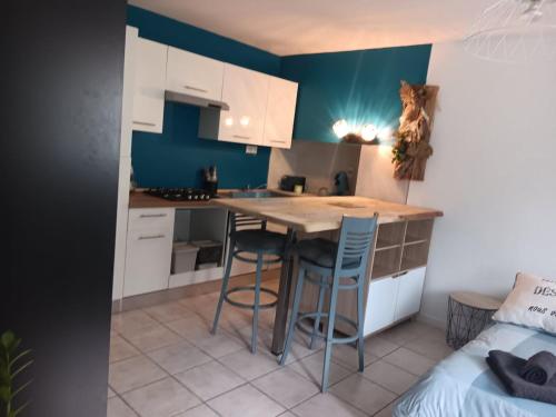 une cuisine avec une table et des chaises dans une pièce dans l'établissement Le Nid Breton, à Pléhédel