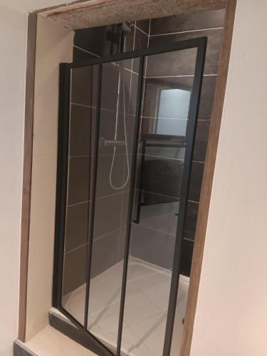 une armoire en verre avec un miroir sur un mur dans l'établissement Le Nid Breton, à Pléhédel